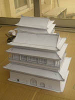 two white models of the bejing drum tower on a brown cardboard box in a veranda